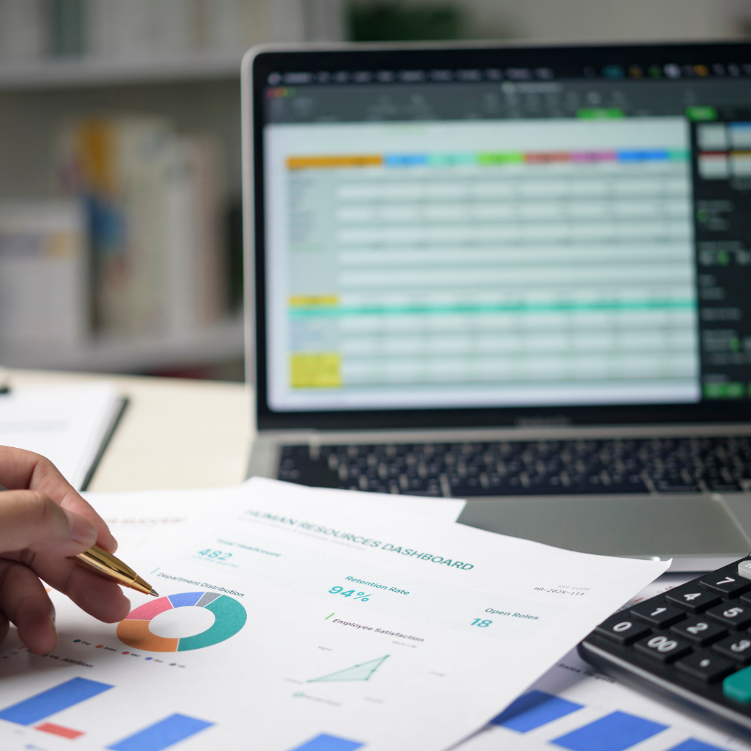 Planilha e relatórios financeiros com calculadora sobre a mesa